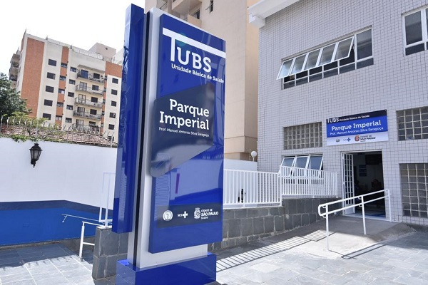 #PraCegoVer: Foto da fachada da UBS Parque Imperial, com a placa da unidade em primeiro plano e destaque. 